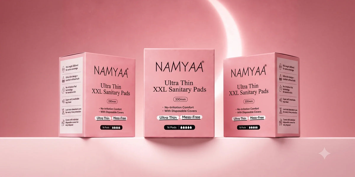Three Namyaa Ultra Thin XXL Sanitary Pads boxes arranged in a softly lit pink studio