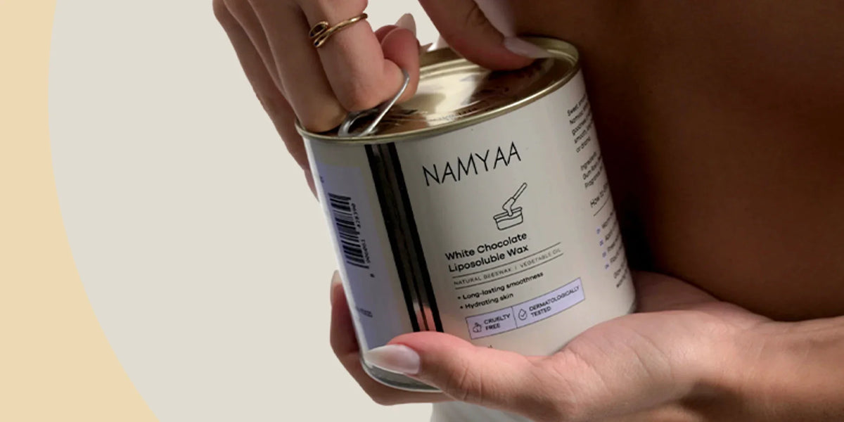 Hands opening a Namyaa White Chocolate Liposoluble Wax tin before warming
