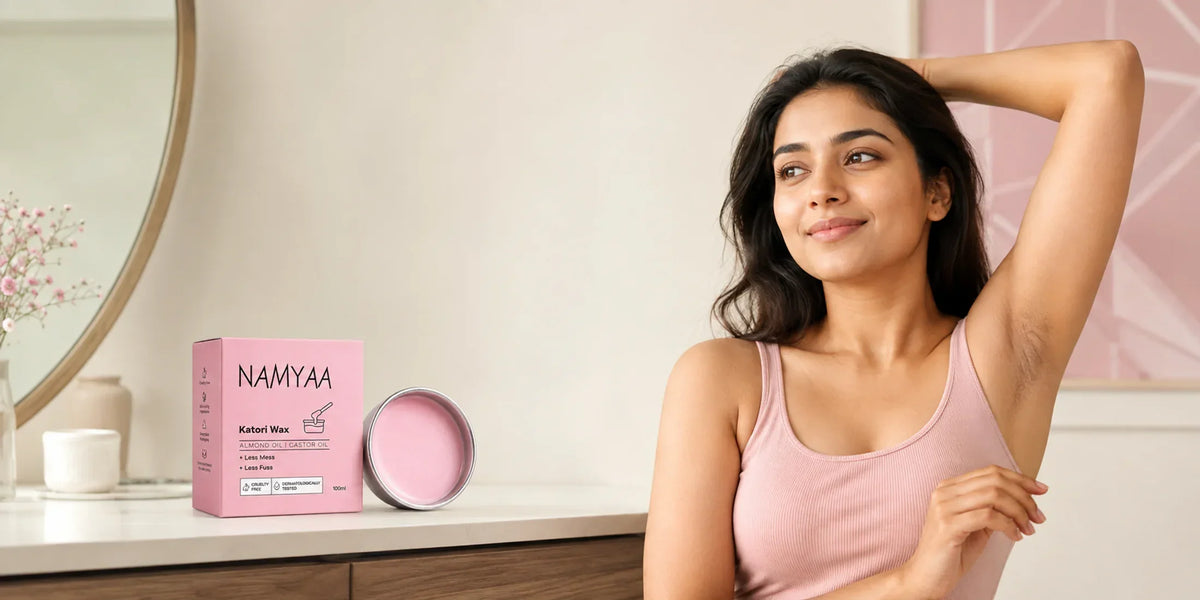 Adult Indian woman raising one arm beside Namyaa Katori Wax in a bright dressing area.