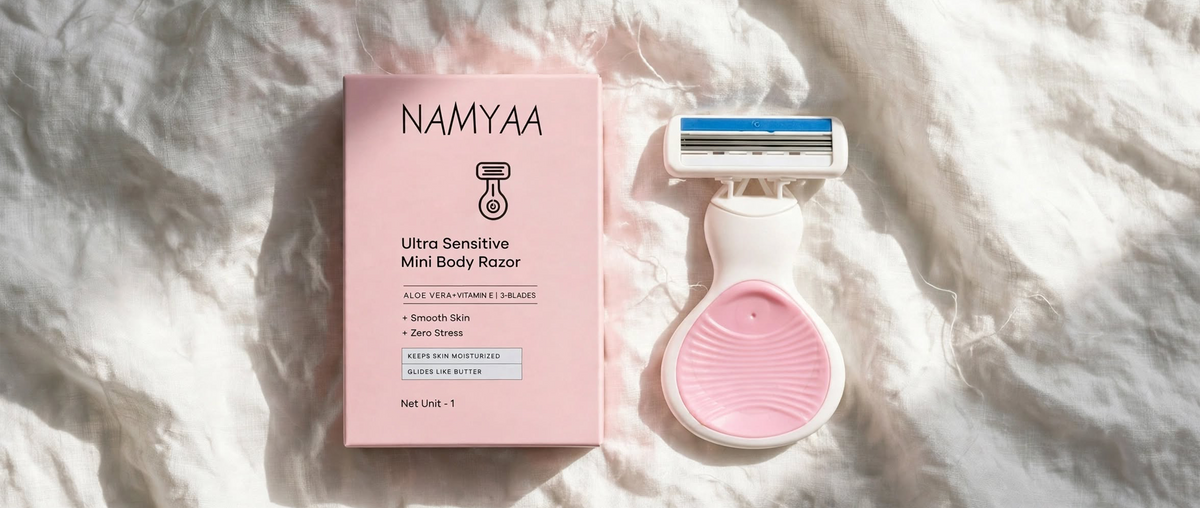 Namyaa Ultra Sensitive Mini Body Razor with Aloe Vera and Vitamin E next to pink product box.