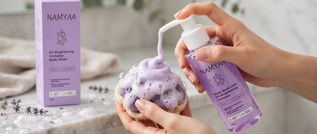 Woman dispensing purple Namyaa Brightening Complex Body Wash enriched with Vitamin C and Alpha Arbutin onto a bathing sponge