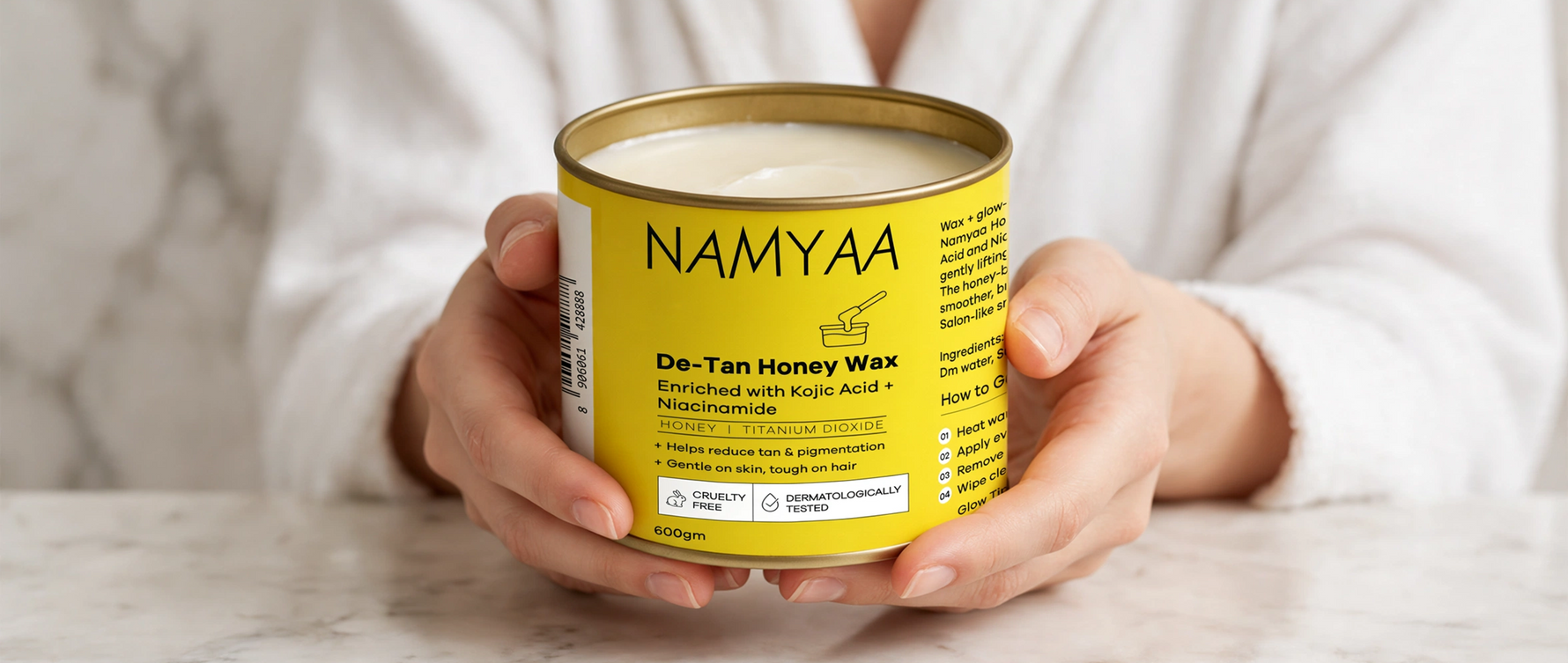 Woman holding a 600gm tin of Namyaa De-Tan Honey Wax for hair removal, tan reduction, and pigmentation control