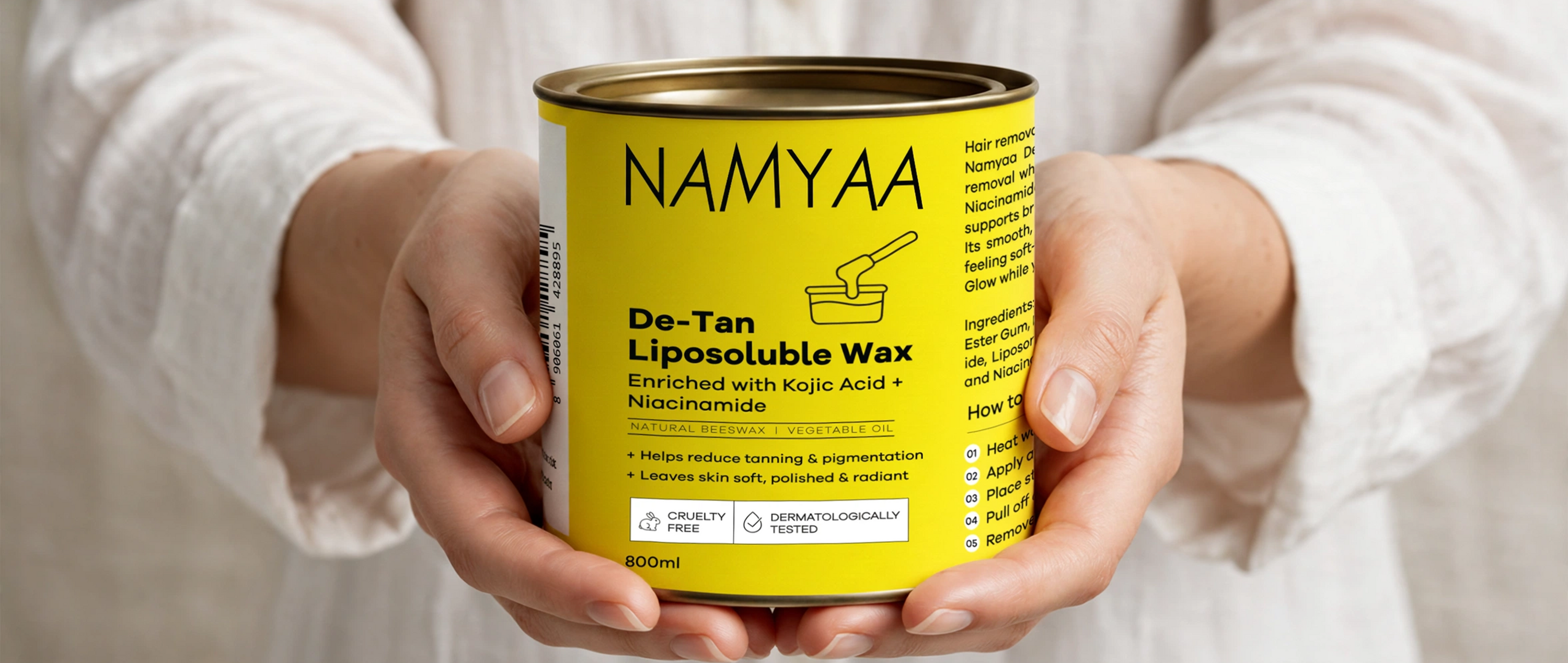 Namyaa De-Tan Liposoluble Wax tin enriched with Kojic Acid and Niacinamide held in hands