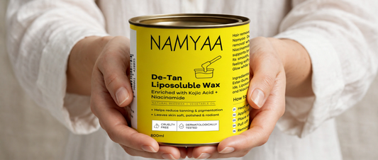 Namyaa De-Tan Liposoluble Wax tin enriched with Kojic Acid and Niacinamide held in hands