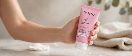 Woman holding pink Namyaa Hair Removal Cream tube for safe and painless 5 minute hair removal